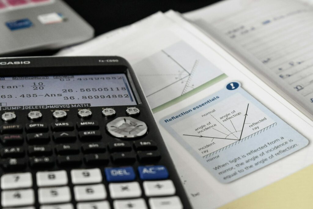Una calcolatrice appoggiata sopra ad un libro di matematica