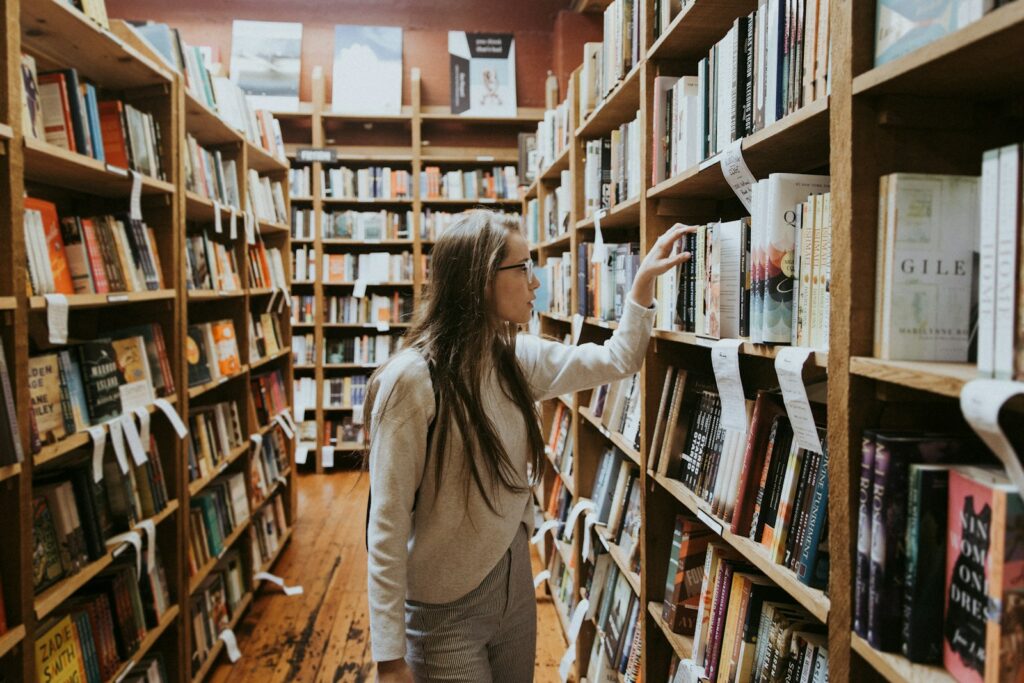 Una ragazza che prende dei libri universitari da una libreria