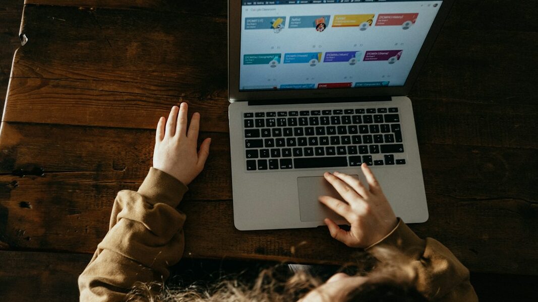 una bambina che usa un pc con libri digitali misti